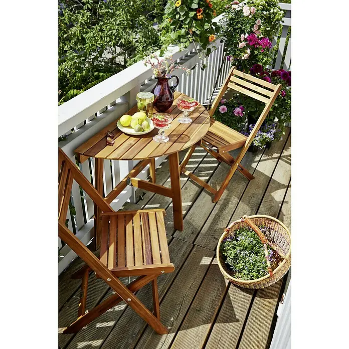 Sunfun Diana Gartenstuhl - Akazie, Klappbar, Naturbraun, B x T x H: 44,5 x 53 x 80 cm - Outdoor-Szene mit einem Holztisch und zwei Stühlen, dekoriert mit Obst, Getränken und Blumen, die eine gemütliche Atmosphäre für Mahlzeiten im Freien schafft.
