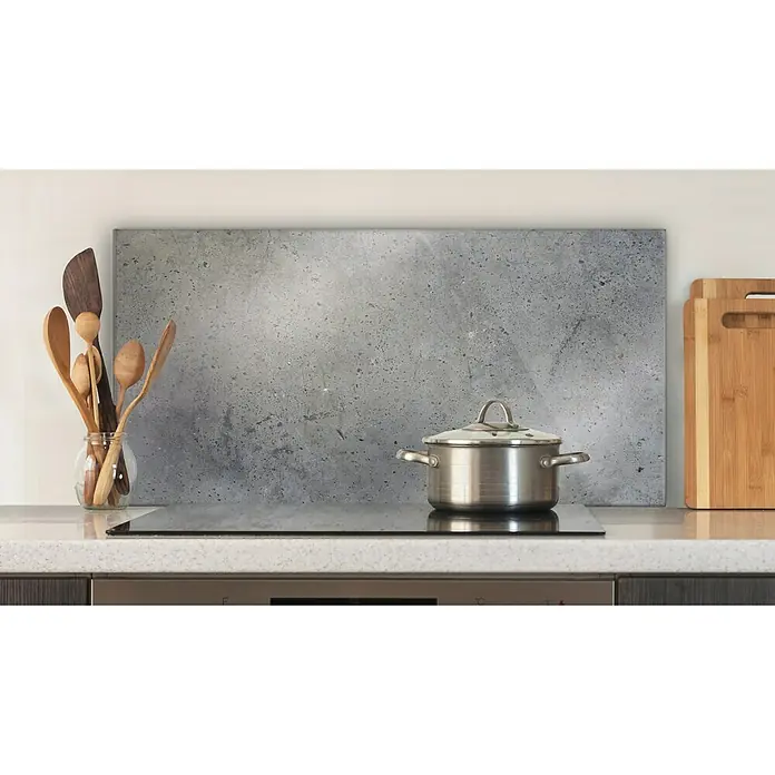 CUCINE Küchenrückwand - Dark Concrete, 80 x 40 cm, Stärke: 6 mm, Einscheibensicherheitsglas (ESG) - Nahaufnahme eines Kochtopfs auf einem Induktionskochfeld in einer modernen Küche, Küchenutensilien und Schneidebretter im Hintergrund.