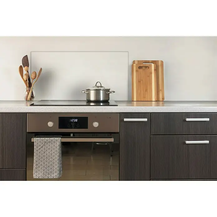 CUCINE Küchenrückwand - Clear, 80 x 40 cm, Stärke: 6 mm, Einscheibensicherheitsglas (ESG) - Einbauherd aus Edelstahl mit dunklen Holzschränken, Kochfeld mit Topf, Holzlöffel und Schneidebrettern auf einer Küchenarbeitsplatte.
