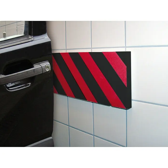 APA Schutzmatte Prall-O-Fit - 12 x 40 x 2 cm, 2 Stk. - Wandschutz mit rot-schwarzen Streifen neben der Tür eines schwarzen Autos. Der Wandschutz verhindert Schäden an der Tür beim Öffnen.