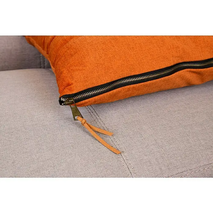 Kissen Finn - Orange, 45 x 45 cm, 100 % Polyester - Nahaufnahme eines orangefarbenen Kissens mit Reißverschlussdetail, das Textur und Design hervorhebt.