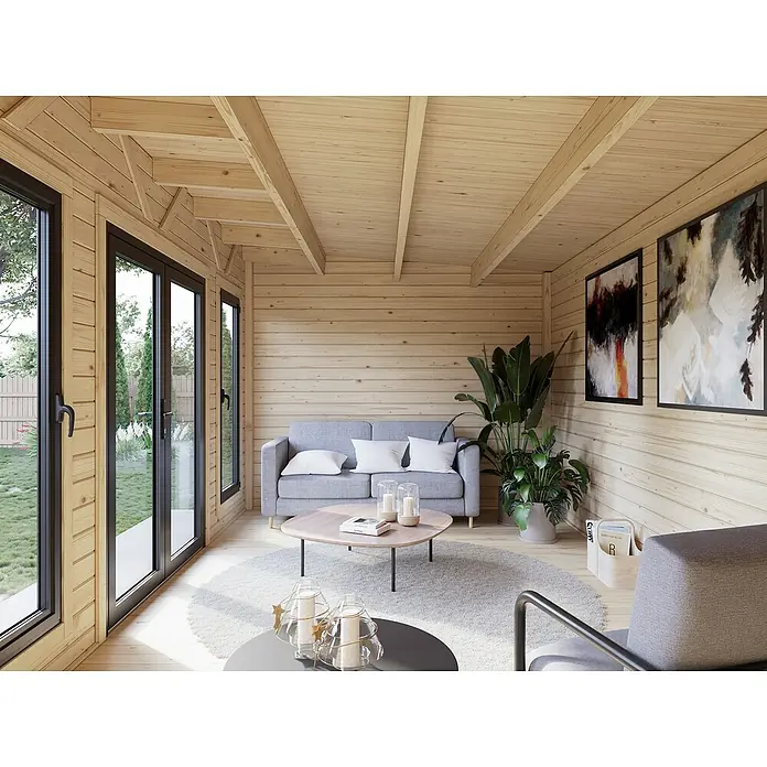 Palmako Gartenhaus Aurelia - Außenmaß inkl. Dachüberstand (B x T): 574 x 404 cm, Holz, Natur unbehandelt - Ein helles, freundliches Blockhaus-Interieur mit grauem Sofa, runden Tischen und Pflanzen, das eine gemütliche Atmosphäre ausstrahlt.