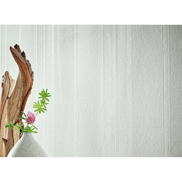 Marburg Home Classic Belvedere Vliestapete Blockstreifen - Grau, Streifen, 10,05 x 0,53 m - Dekoratives Stillleben mit abstrakter Holzskulptur, rosa Klee und einer stilvollen Vase vor einem strukturierten, weißen Hintergrund.