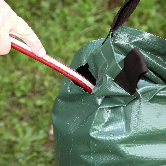 Floraworld Bewässerungssack Comfort - Passend für: Bäume bis Ø 18 cm, 400 g/m² - Ein grüner, wasserdichter Beutel mit schwarzen Trägern, in den ein Schlauch gesteckt wird. Ideal für Camping und Outdoor-Aktivitäten.