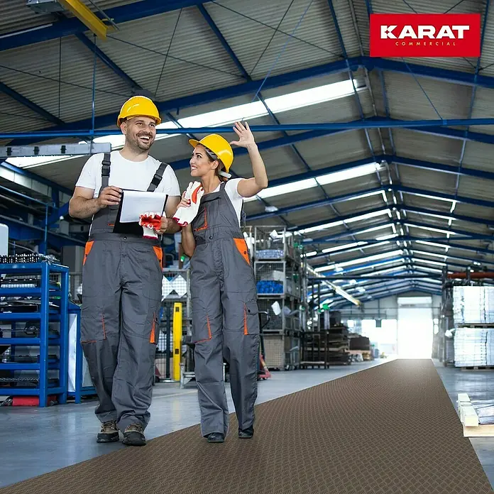 Floordirekt Läufer Diamond Cut - 120 x 400 cm, Braun - Zwei Bauarbeiter mit gelben Helmen stehen auf einer braunen Karat Commercial-Bodenmatte in einer Fabrik.