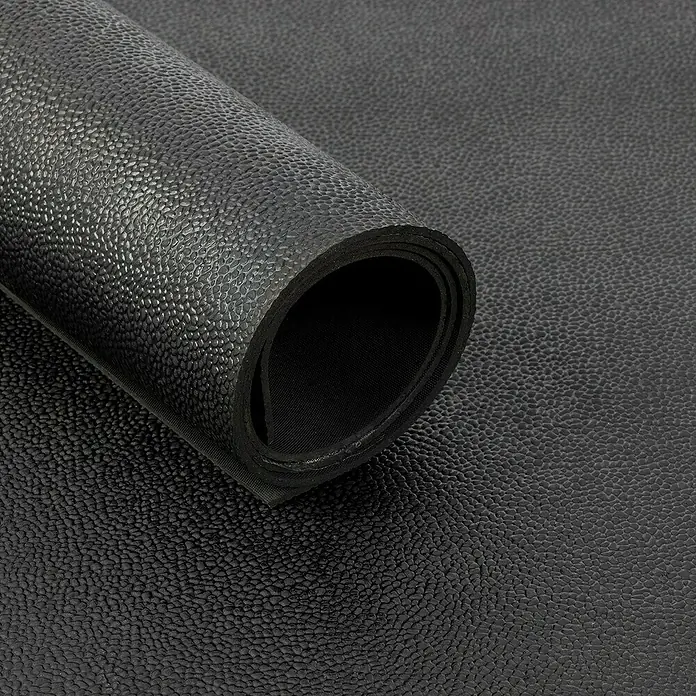 Floordirekt Läufer Orange Peel - 100 x 50 cm, Schwarz - Nahaufnahme einer schwarzen, strukturierten Gummimatte, die aufgerollt ist und ihre Textur und Dicke zeigt. Ideal für Sport oder als Unterlage.