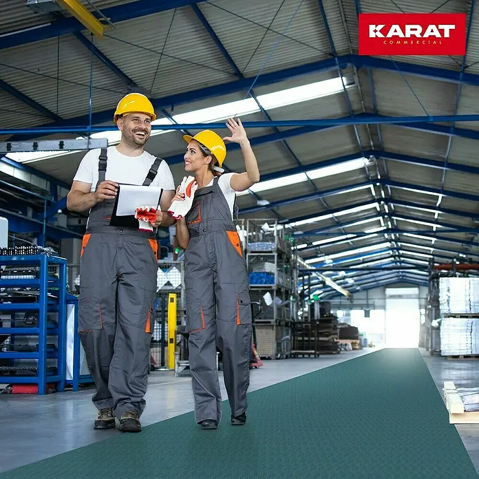 Floordirekt Läufer Diamond Cut - 120 x 400 cm, Türkis - Zwei Arbeiter auf einer grünen Karat Commercial Bodenmatte in einer Fabrik. Die Matte bietet Komfort und Sicherheit.