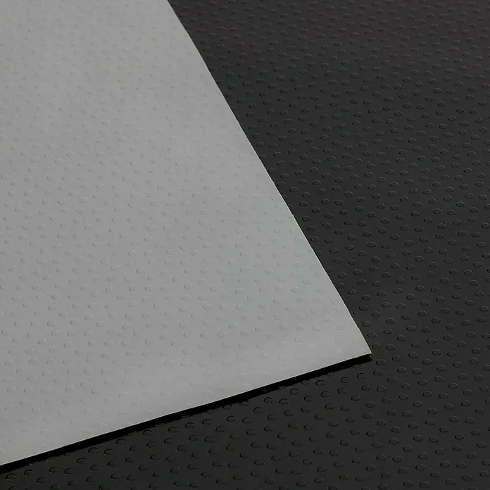 Floordirekt Läufer Dots - 120 x 50 cm, Schwarz - Detailaufnahme einer strukturierten, hellgrauen Oberfläche, die sich von einem schwarzen, genoppten Hintergrund abhebt. Ideal für Texturen.