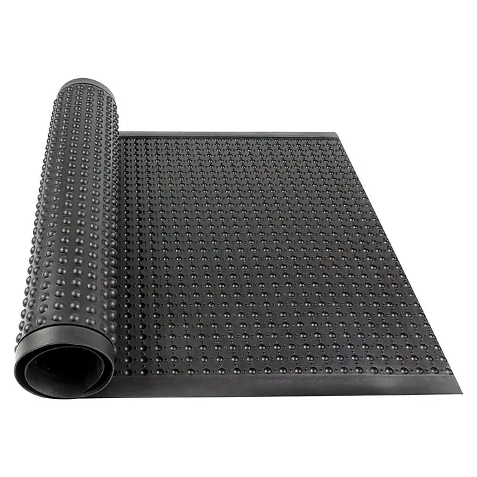 Floordirekt Bodenschutzmatte Bubble - Schwarz, 90 x 60 cm - Nahaufnahme einer schwarzen Noppenbahn, teilweise aufgerollt, die ihre Textur und Verwendung für Feuchtigkeitsschutz und Drainage hervorhebt.