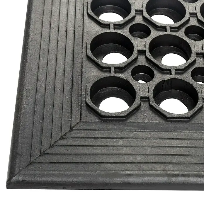 Floordirekt Läufer - 90 x 150 cm, Schwarz - Nahaufnahme einer schwarzen Gummimatte mit Löchern und Rillen, ideal für Nassbereiche und Eingänge. Rutschfest und strapazierfähig.