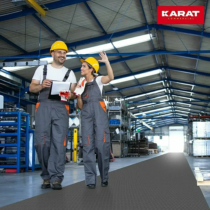 Floordirekt Läufer Diamond Cut - 120 x 250 cm, Dunkelgrau - Bild eines Karat-Bodenbelags in einer Lagerhalle, auf dem zwei Arbeiter mit Schutzhelmen stehen.