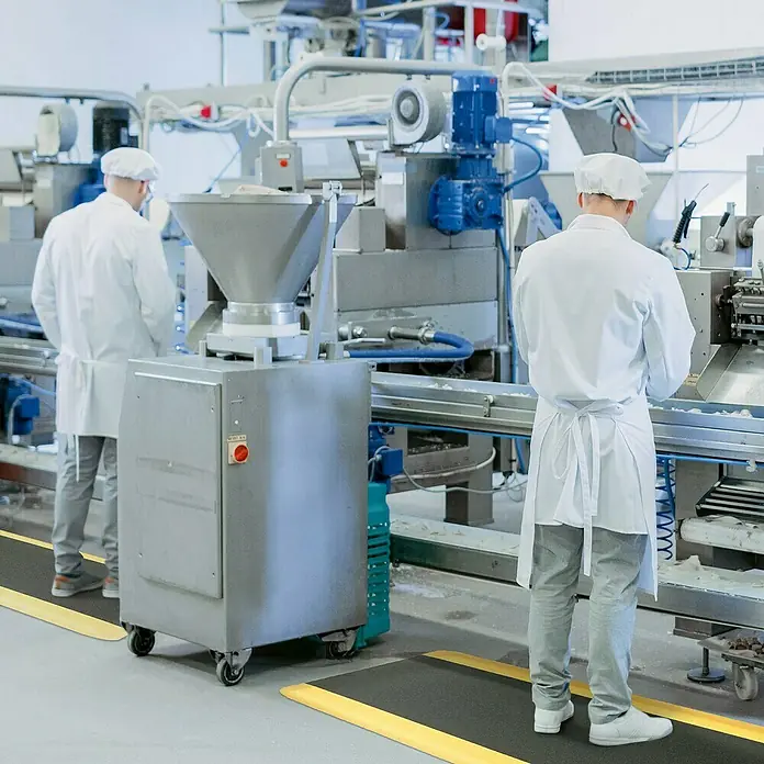 Floordirekt Bodenschutzmatte Soft-Tritt - 120 x 450 cm, Gelb/Schwarz - Bild einer gelben und schwarzen Anti-Ermüdungsmatte in einer Fabrik, die Komfort und Sicherheit für Arbeiter bietet.