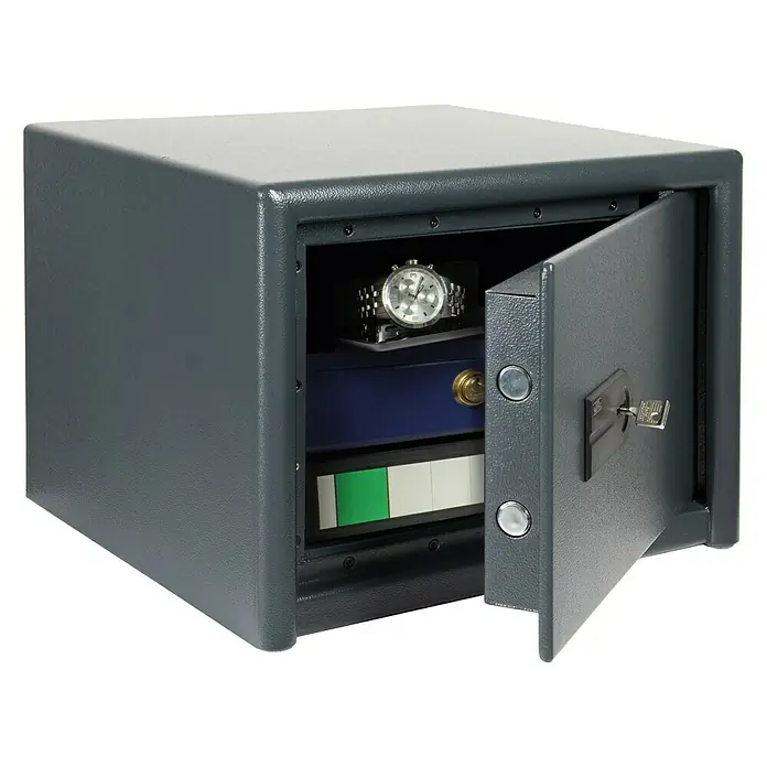 Burg-Wächter Möbeltresor Magno M 520 S - L x B x H: 445 x 495 x 360 mm, Anthrazit, Doppelbart-Hochsicherheitsschloss - Grauer Safe mit offenem Tresorraum, in dem sich eine Uhr, eine blaue Box und andere Gegenstände befinden.