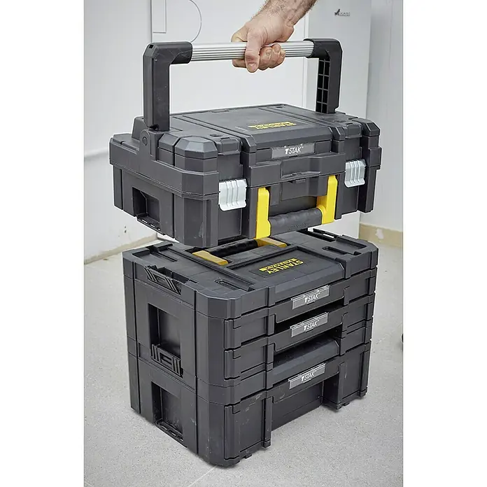 Stanley TSTAK Caja para herramientas FMST1-71967 - An x Pr x Al: 33,17 x 44 x 18,5 cm, Plástico - Una solución de almacenamiento de caja de herramientas modular y apilable Stanley Fatmax en negro y amarillo, que consta de diferentes elementos, levantada por el usuario.
