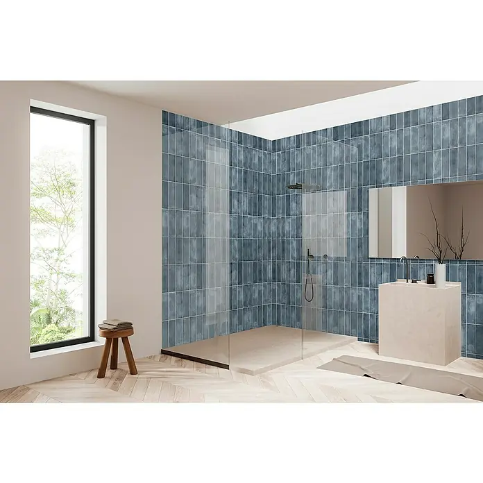 Bariperfil Panel de pared Corewall Merlin - 258 x 102,3 cm, Azul - Elegante diseño de baño con azulejos azules, ducha moderna y lavabo. El parqué de madera clara aporta calidez y contraste.