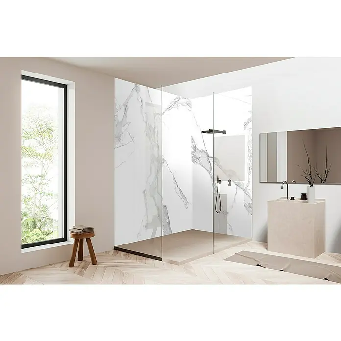 Bariperfil Panel de pared Corewall Carrara - 258 x 102,3 cm, Blanco - Un baño moderno con una ducha a ras de suelo con paredes de mármol, un elegante mueble de lavabo y una gran ventana con vistas a la vegetación.