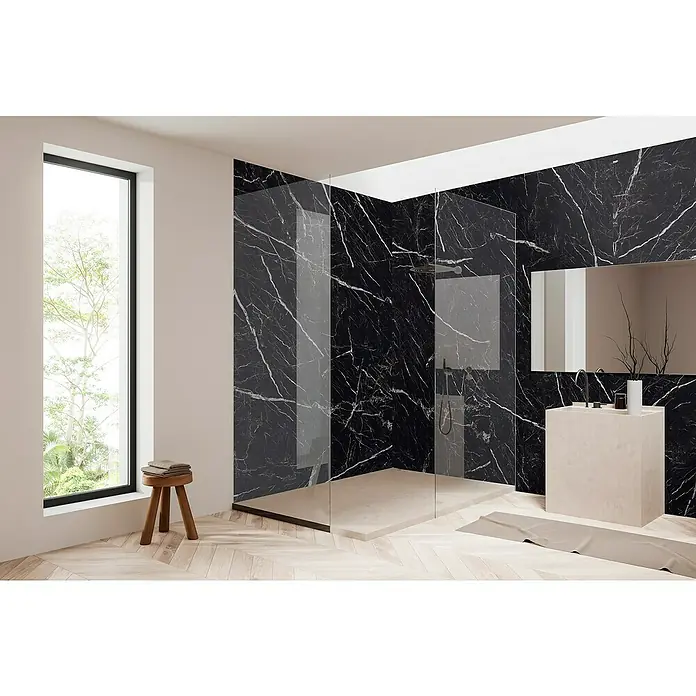 Bariperfil Panel de pared Corewall Infinite - 258 x 102,3 cm, Negro - Baño luminoso con pared de mármol y ducha. El tocador es de piedra clara, la ventana es luminosa y el suelo es de parquet claro.