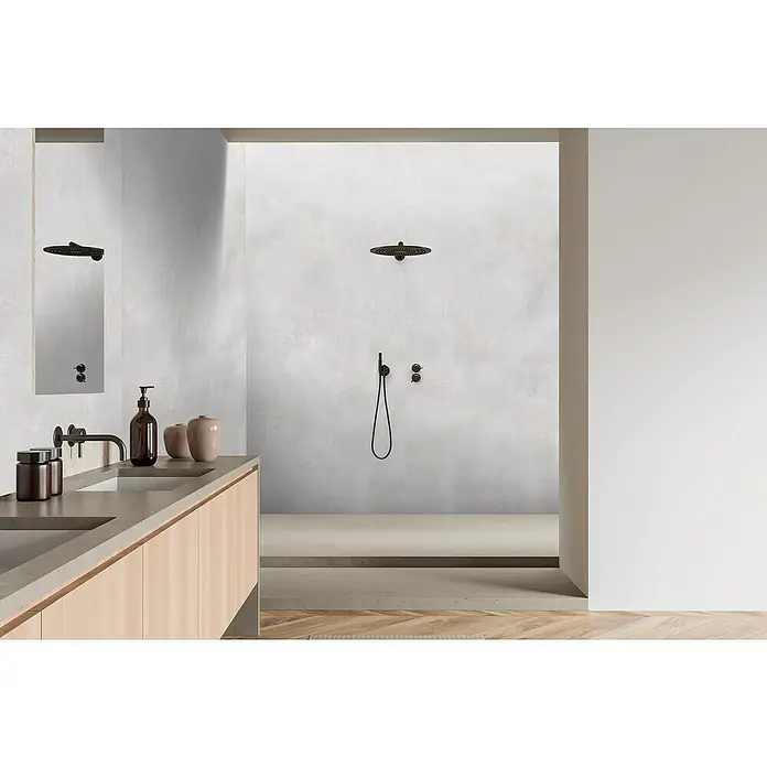 Bariperfil Panel de pared Corewall Concrete - 258 x 102,3 cm, Gris - Interior de baño que muestra un tocador moderno y una ducha elegante con accesorios oscuros sobre un fondo gris claro.