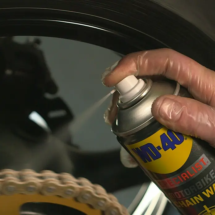 WD-40 Specialist Motorbike Kettenwachs - 400 ml - WD-40 Specialist Motorradkettenreiniger wird auf eine Motorradkette aufgesprüht.