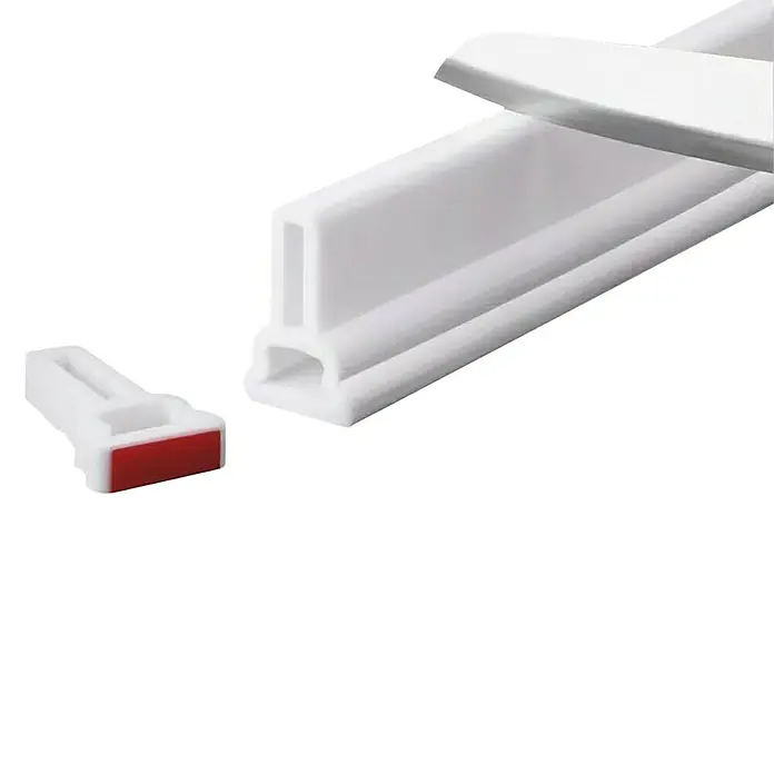 Perfil de sellado - 1,5 m x 38 mm x 28 mm, Blanco, PVC - Primer plano de una tira de sellado de puerta blanca y un clip de montaje con tira adhesiva roja.