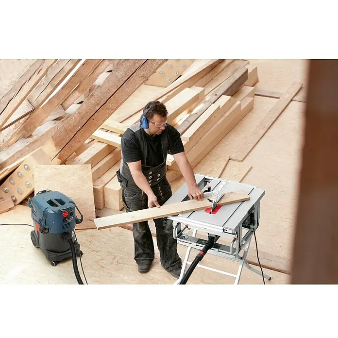 Bosch Professional Tischkreissäge GTS 10 J - 1.800 W, Durchmesser Sägeblatt: 254 mm, Schnitttiefe bei 90 °: 79 mm - Ein Mann arbeitet mit einer Bosch Tischkreissäge an einem Holzbrett, er trägt Schutzkleidung.