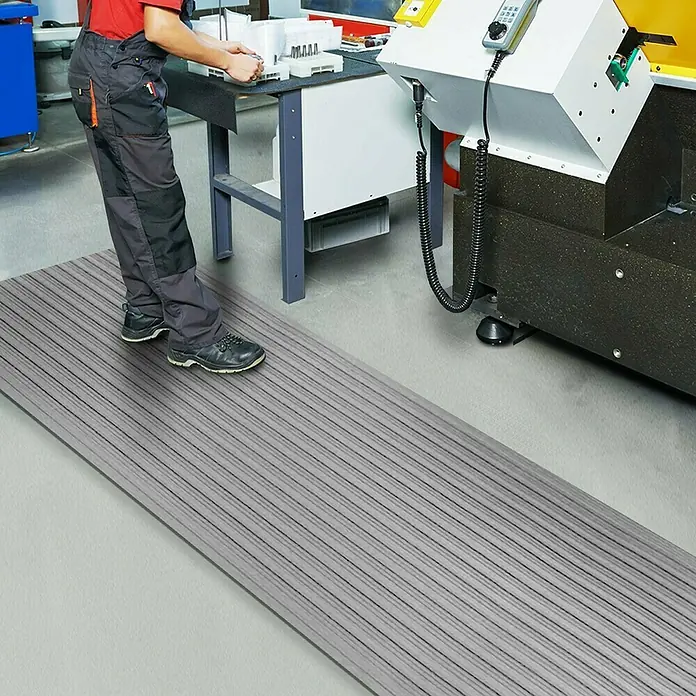 Floordirekt Läufer Softer-Work-Mat - 120 x 800 cm, Grau - Graue, gerippte Antiverschleißmatte, die auf einem Industrieboden liegt und für Komfort und Sicherheit konzipiert ist.