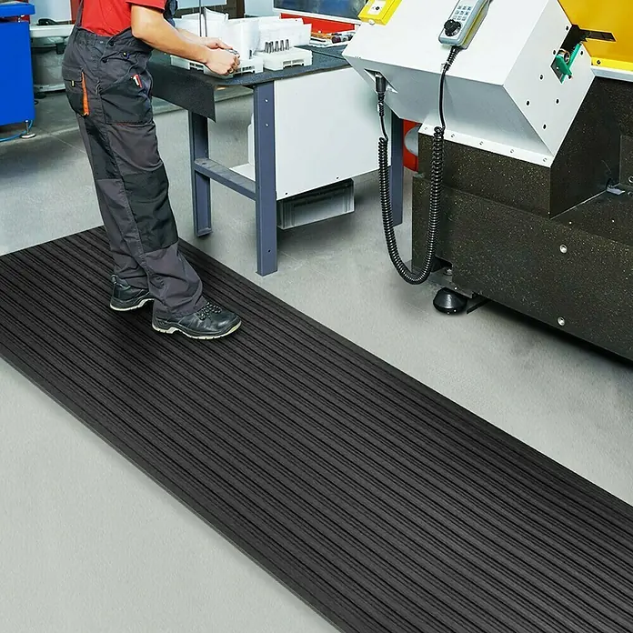 Floordirekt Läufer Softer-Work-Mat - 120 x 800 cm, Schwarz - Eine robuste, schwarze Antirutschmatte für Industrie und Gewerbe liegt auf dem Boden und bietet sicheren Stand bei der Arbeit.