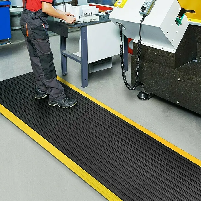 Floordirekt Läufer Softer-Work-Mat - 120 x 50 cm, Gelb/Schwarz - Eine schwarze, gerippte Gummimatte mit gelben Rändern, die für zusätzliche Sicherheit und Komfort in Industrieumgebungen sorgt.