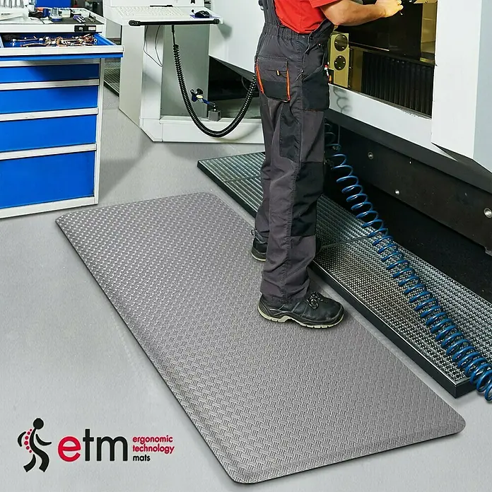 Floordirekt Bodenschutzmatte Heavy-Duty TireTuff - 90 x 150 cm, Grau - Ein graue ETM-Ergonomiematte liegt auf dem Boden. Die Matte ist strukturiert und bietet Komfort bei stehenden Tätigkeiten am Arbeitsplatz.