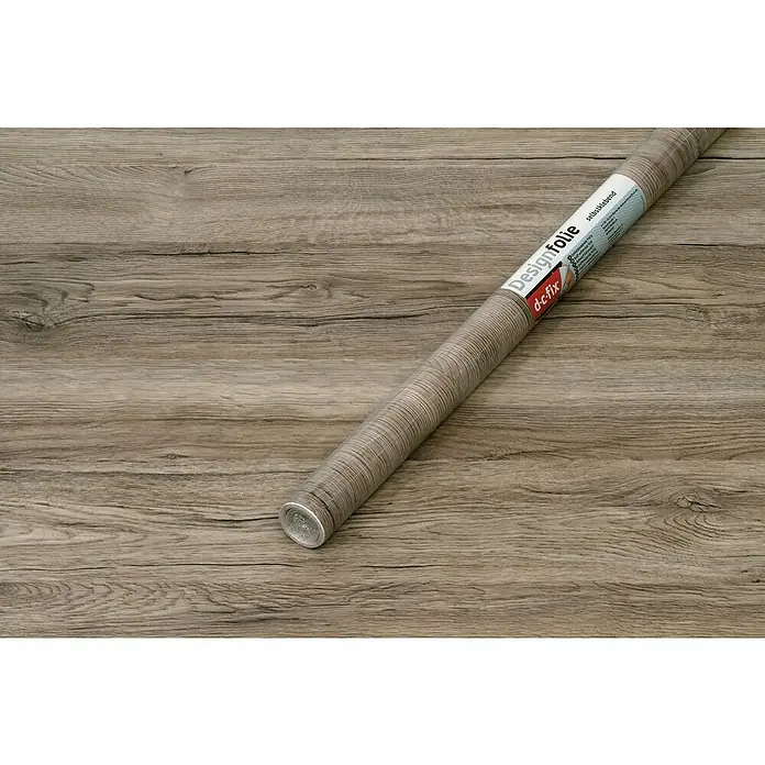 D-c-fix Holzoptikfolie Sanremo Eiche - 200 x 67,5 cm, Sepia, Selbstklebend - Ein D-c-fix Designfolie Rolle in Holzoptik liegt auf einem Holztisch. Die Folie ist selbstklebend und bietet eine einfache Möglichkeit zur Dekoration.