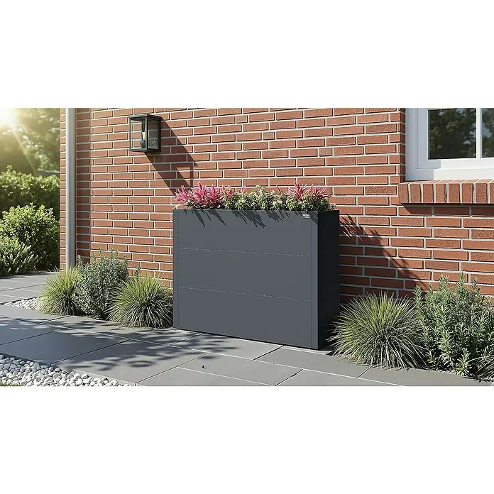 Weka Hochbeet Gary - 100 x 30 x 77 cm, Metall, Anthrazit - Eine moderne, graue Blumenkasten-Sichtschutzwand von Edeka, bepflanzt mit Blumen und Grünpflanzen, vor einer roten Backsteinmauer.