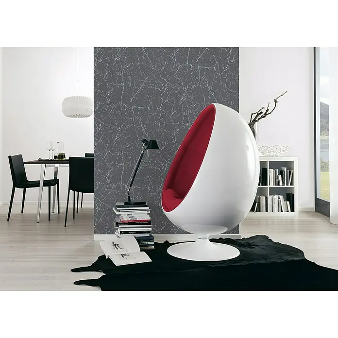 A.S. Création Elegance 3 Vliestapete Verzweigte Äste - Grau/Metallic, Floral, 10,05 x 0,53 m - Ein eleganter, moderner Raum mit einem auffälligen, weißen Eiersessel mit roter Innenausstattung als zentralem Element.