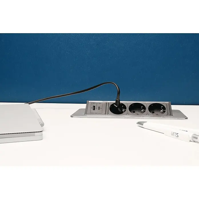 UniTEC Tischsteckdose USB-A, USB-C - Versenkbar, Silber, 40 x 13 x 12,3 cm - Eine versenkbare Tischsteckdose mit USB-Anschlüssen und Netzsteckdosen, ein Laptop und ein Stift sind auf einem Schreibtisch platziert.