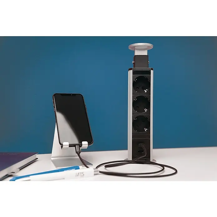UniTEC Tischsteckdose USB-A, USB-C - Versenkbar, Silber/Schwarz, 10,2 x 11 x 40 cm - Das Bild zeigt eine ausfahrbare Steckdosenleiste mit USB-Anschluss und ein Smartphone, das an einem Ständer mit Ladekabel befestigt ist.