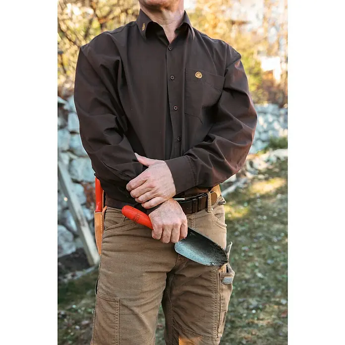 Felco Blumenkelle 401 - 33 cm - Eine Person in braunem Hemd und Hose hält eine Schaufel, die auf robuste Arbeitskleidung und Gartenarbeit hinweist.