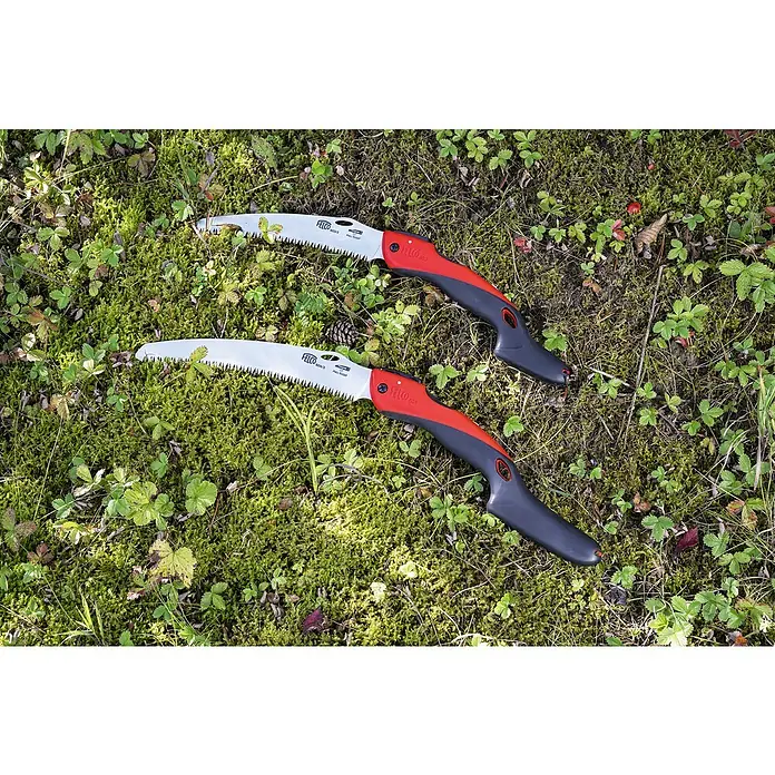 Felco Klappsäge 603 - Max. Aststärke: 100 mm - Zwei FELCO 604 Astsägen liegen im Gras. Die Sägen haben einen rot-schwarzen Griff und ein silbernes Sägeblatt.