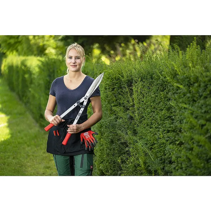 Felco Hand-Heckenschere 250-63 - L x B x H: 71 x 25 x 11 cm, Rot - Eine Frau hält eine FELCO Heckenschere vor einer grünen Hecke. Die FELCO Heckenschere ist ideal für den Gartenschnitt.