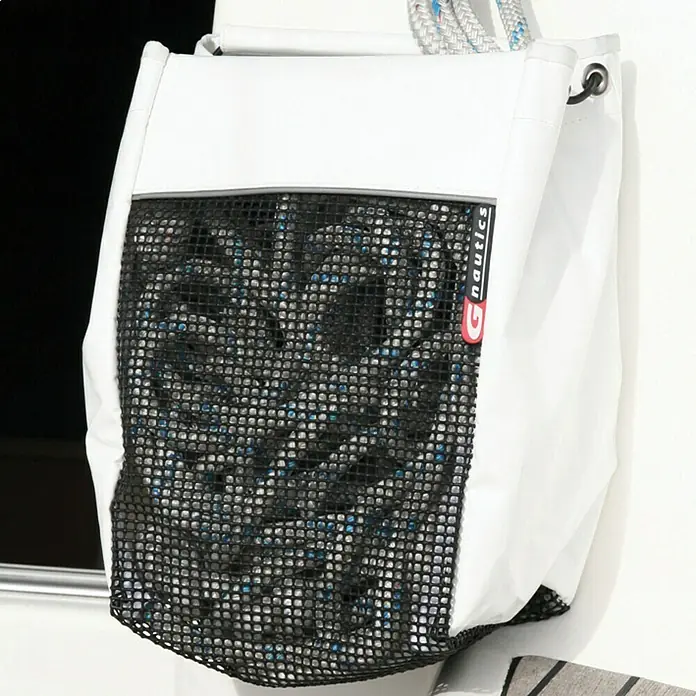 G-Nautics Leinentasche S - L x B x H: 18 x 20 x 30 cm, Weiß/Schwarz - Eine weiße nautische Aufbewahrungstasche mit schwarzem Netz und gefülltem Seil hängt an einer weißen Wand.