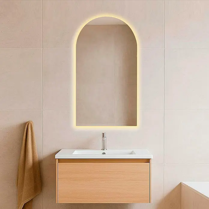 Camargue Espejo con luz Carla - 50 x 90 cm, Blanco cálido - Un baño moderno con un espejo de arco iluminado sobre un tocador flotante con acabado de madera.