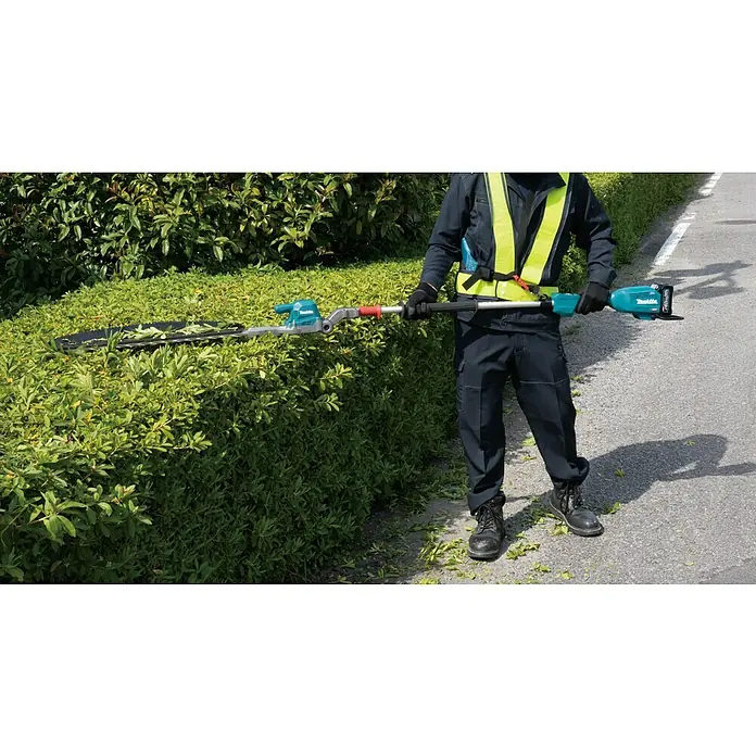 Makita XGT 40V max. Akku-Heckenschere UN001G - 40 V, Li-Ionen, Ohne Akku, Schnittlänge: 600 mm - Ein Mann trimmt eine Hecke mit einer Makita Akku-Heckenschere mit Teleskopstiel und Akku. Das Gerät ermöglicht komfortables Schneiden hoher Hecken.