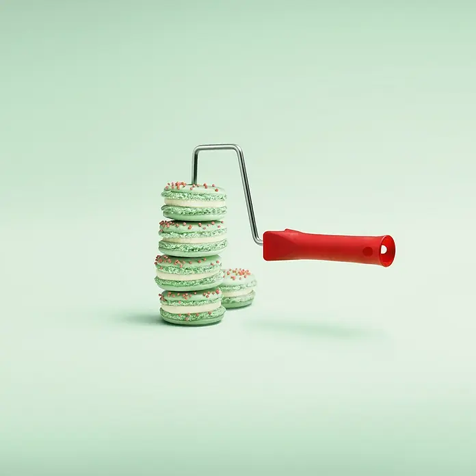 SCHÖNER WOHNEN-Farbe Wandfarbe Trendfarbe - Macaron, Matt, 2,5 l, Konservierungsmittelfrei - Das Bild zeigt einen Turm aus grünen Macarons mit rotem Dekor, präsentiert mit einer Farbwalle, die Kreativität und Geschmack vereint.