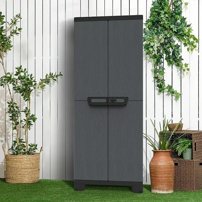 Terry Kunststoff-Mehrzweckschrank CAB 2680 ARDESIA - H x B x T: 172 x 39 x 68 cm, Schwarz - Das Bild zeigt einen grauen Gartenschrank mit zwei Türen vor einem weißen Lattenzaun. Pflanzen und Dekorationen umgeben den Schrank.