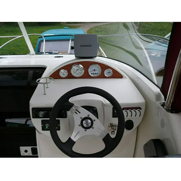 PEGAZUS GFK-Boot Escapade 600 Base SunTop - Max. 6 Personen, Nutzlast: 660 kg, CE-Klasse C - Das Steuerpult eines Bootes mit einem Garmin Navigationssystem im Fokus, umgeben von klassischen Instrumenten und dem Steuerrad.