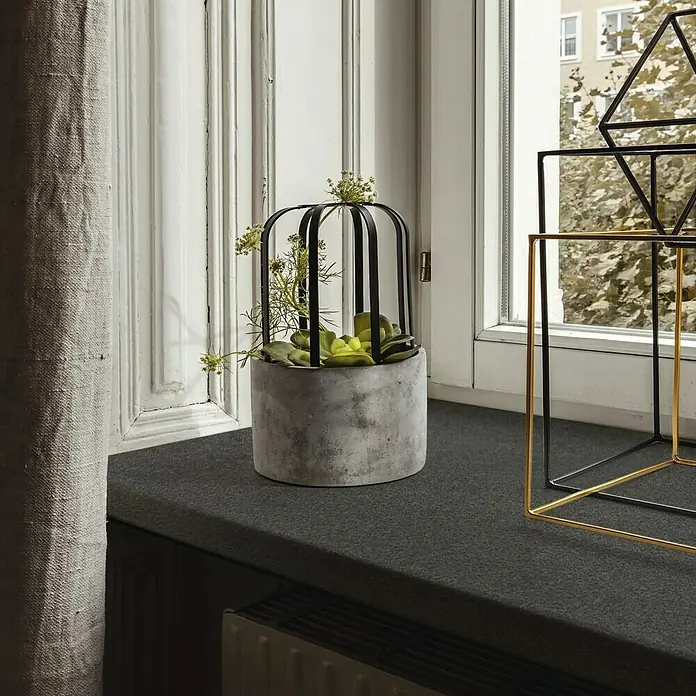 Küchenarbeitsplatte nach Maß - Mocca, Stärke: 3,8 cm, Breite: 60 cm - Nahaufnahme eines zylindrischen Topfes mit Pflanzen in einem dekorativen Käfig auf einer Fensterbank, neben abstrakten Deko-Objekten.