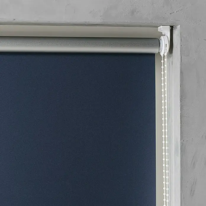 Rollo Basic - B x H: 100 x 175 cm, Blau, Uni, Verdunkelnd - Ein Rollo in dunklem Blauton ist teilweise heruntergelassen und hängt vor einem Fenster. Der Mechanismus ist in Weiß gehalten.
