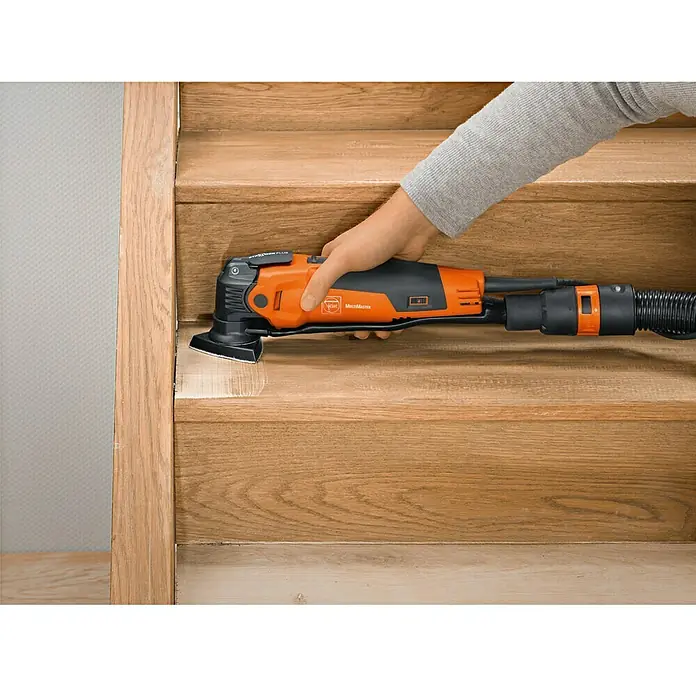 Fein Set de aspiración - Específico para: Multiherramienta Fein MultiMaster 350 Q/QSL, 21 pzs. - La imagen muestra una herramienta eléctrica oscilante FEIN MultiMaster lijando una escalera de madera para su renovación.