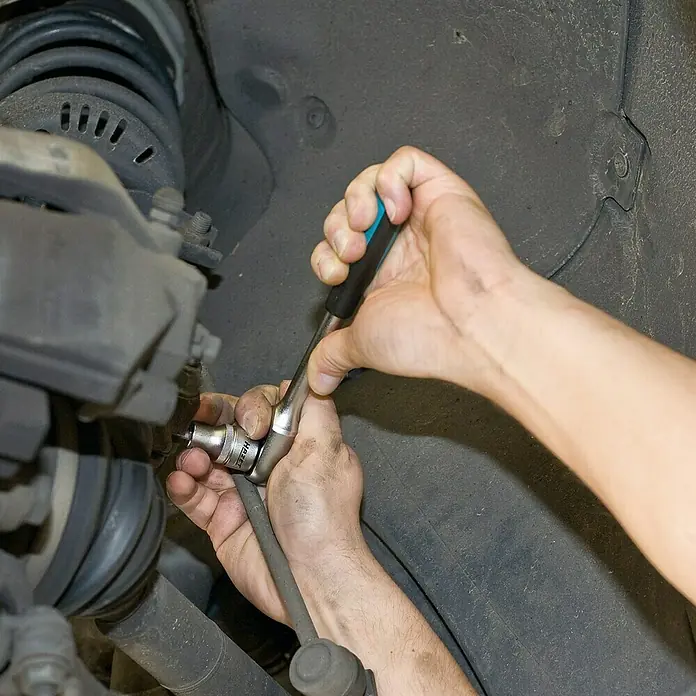 Hazet Radlagergehäuse-Spreizer 4912-1 - Schlüsselweite: 5,5 mm - 8 mm, Antriebsgröße: ½″ - Ein Mechaniker verwendet einen Steckschlüssel, um an einem Autorad zu arbeiten, wobei er den Schraubenkopf präzise bearbeitet, um die Reparatur auszuführen.