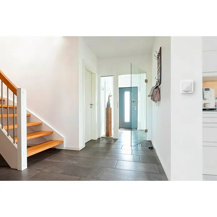 Bosch Smart Home Universalschalter - Reichweite Funk: 101 m, Aufputz - Ein quadratischer Bosch Smart Home Lichtschalter an einer weißen Wand. Der Schalter ist elegant und modern gestaltet.