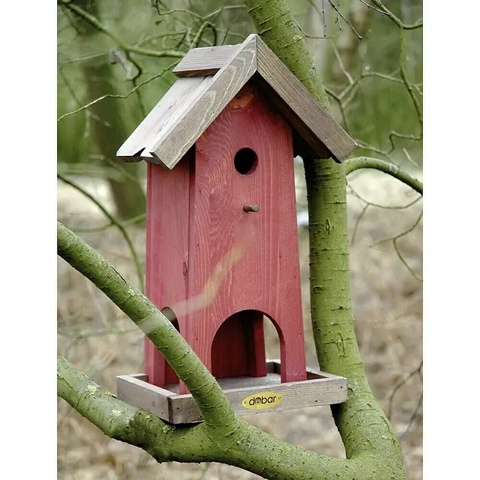 Dobar Vogelhaus Penthouse - 26,5 x 18,5 x 45 cm, Holz, Rot/Braun - Ein rotes Vogelhaus mit braunem Dach, montiert auf einem Baumast, bietet Vögeln einen sicheren Futterplatz.
