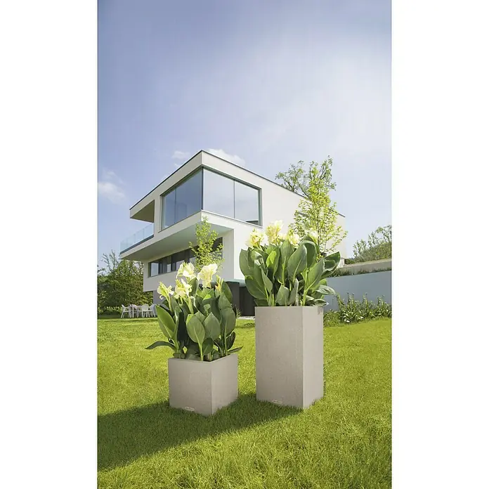 Lechuza Color Pflanzsäule eckig Canto - Außenmaß (L x B x H): 40 x 40 x 76 cm, Kunststoff, Sandbeige - Elegante Pflanzgefäße mit üppigen Blüten vor einem modernen Haus. Perfekt für stilvolle Gartengestaltung und Außenbereiche.